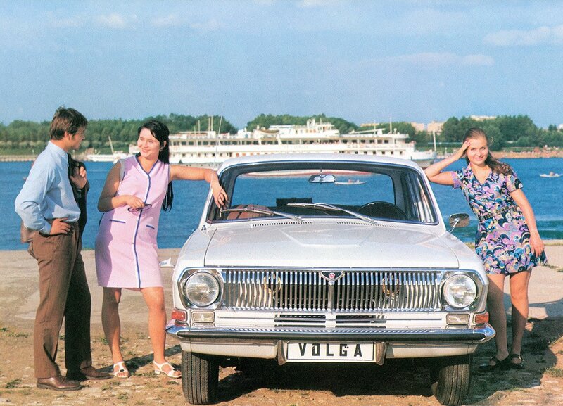 People with a Volga car by the water