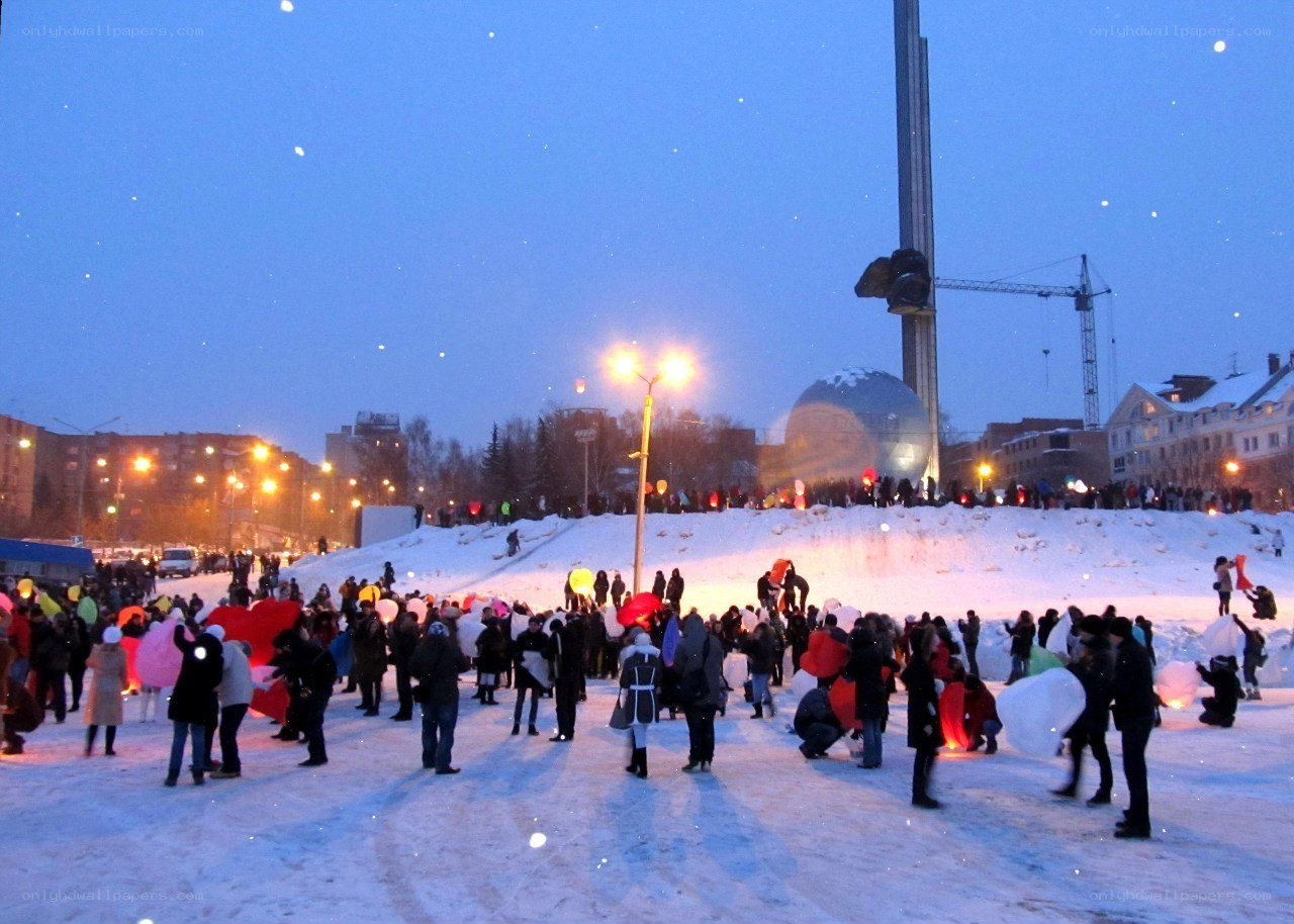 People with lanterns in snow