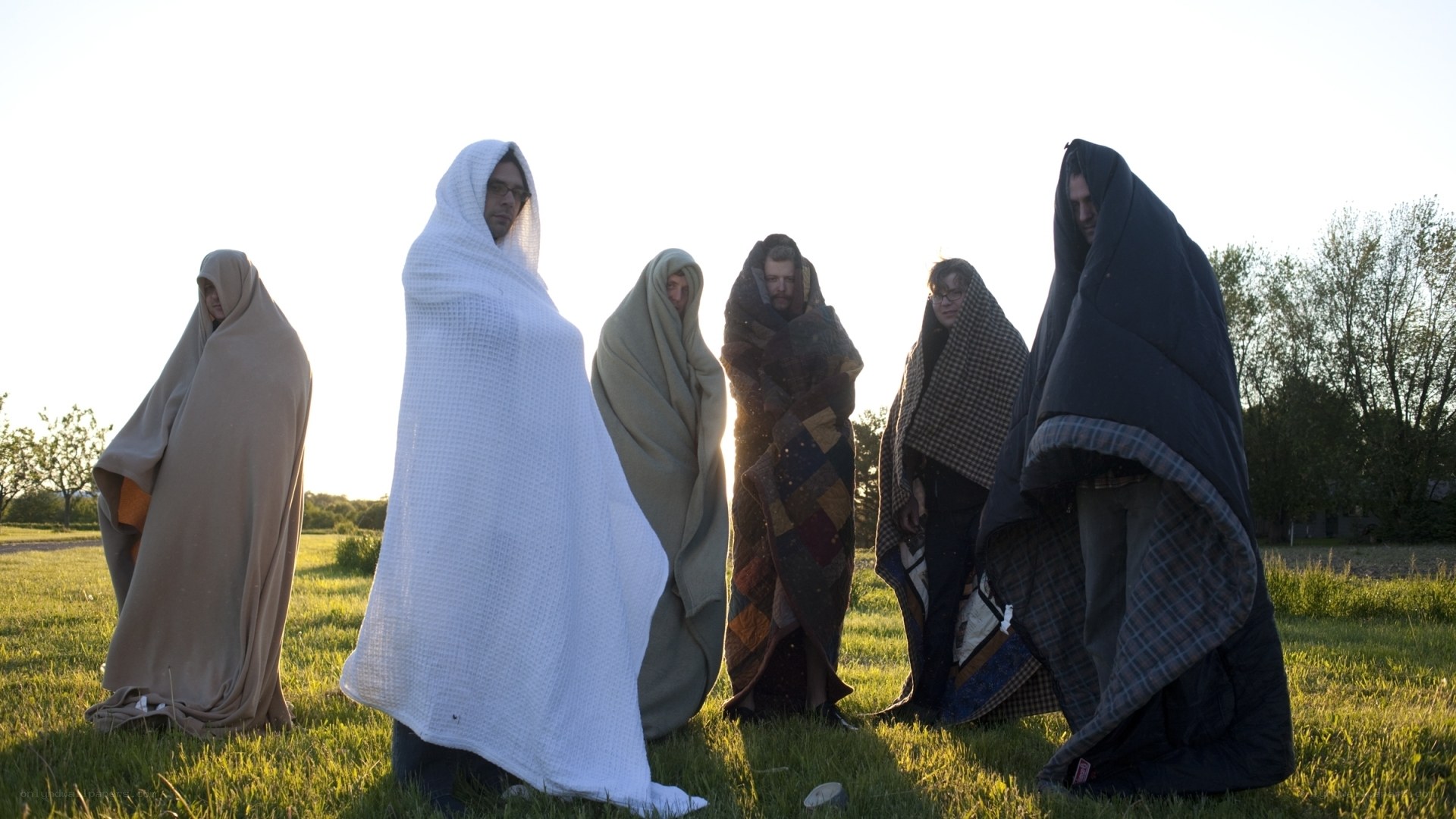 people wrapped in blankets outdoors