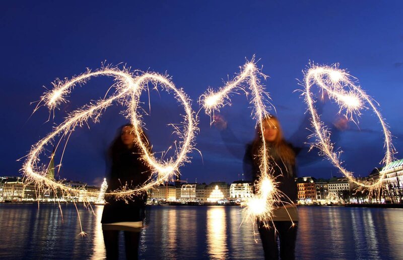 People writing with sparklers at night