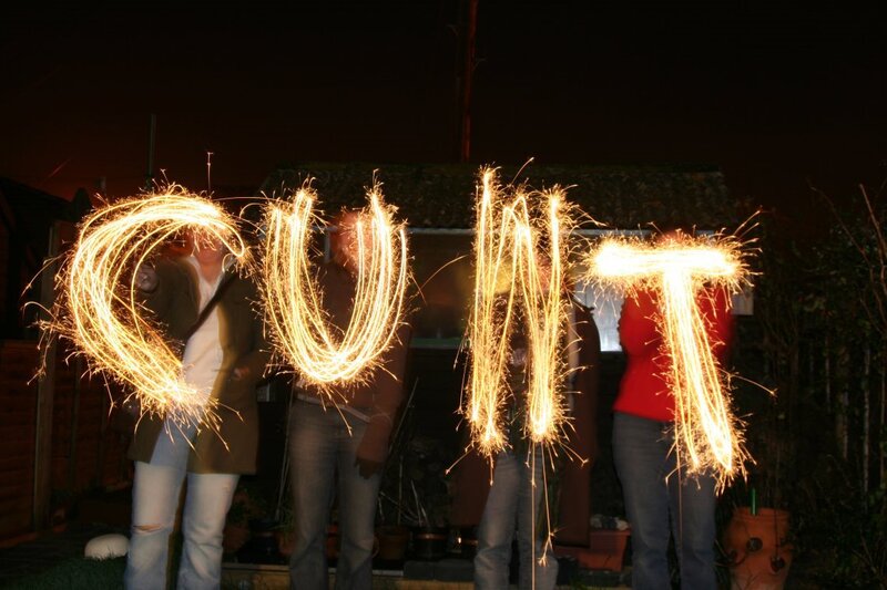 People writing with sparklers at night