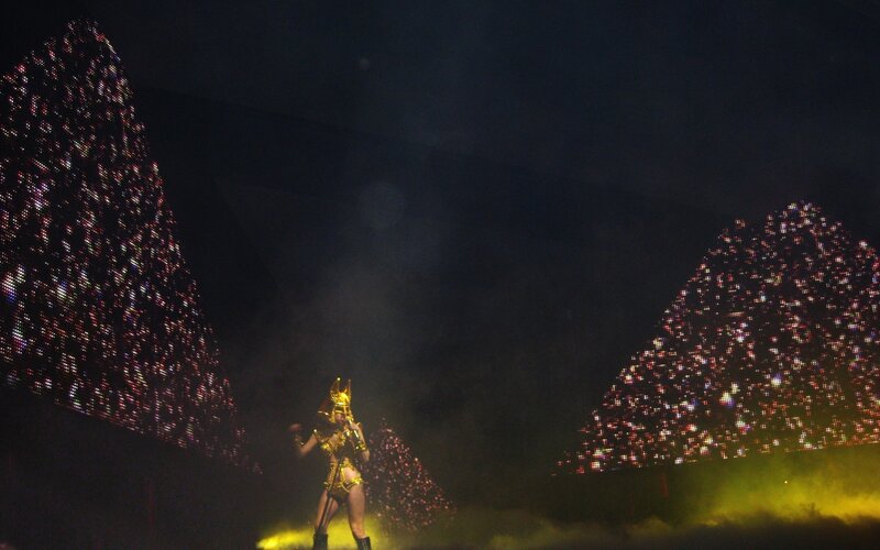 performer on stage with pyramids