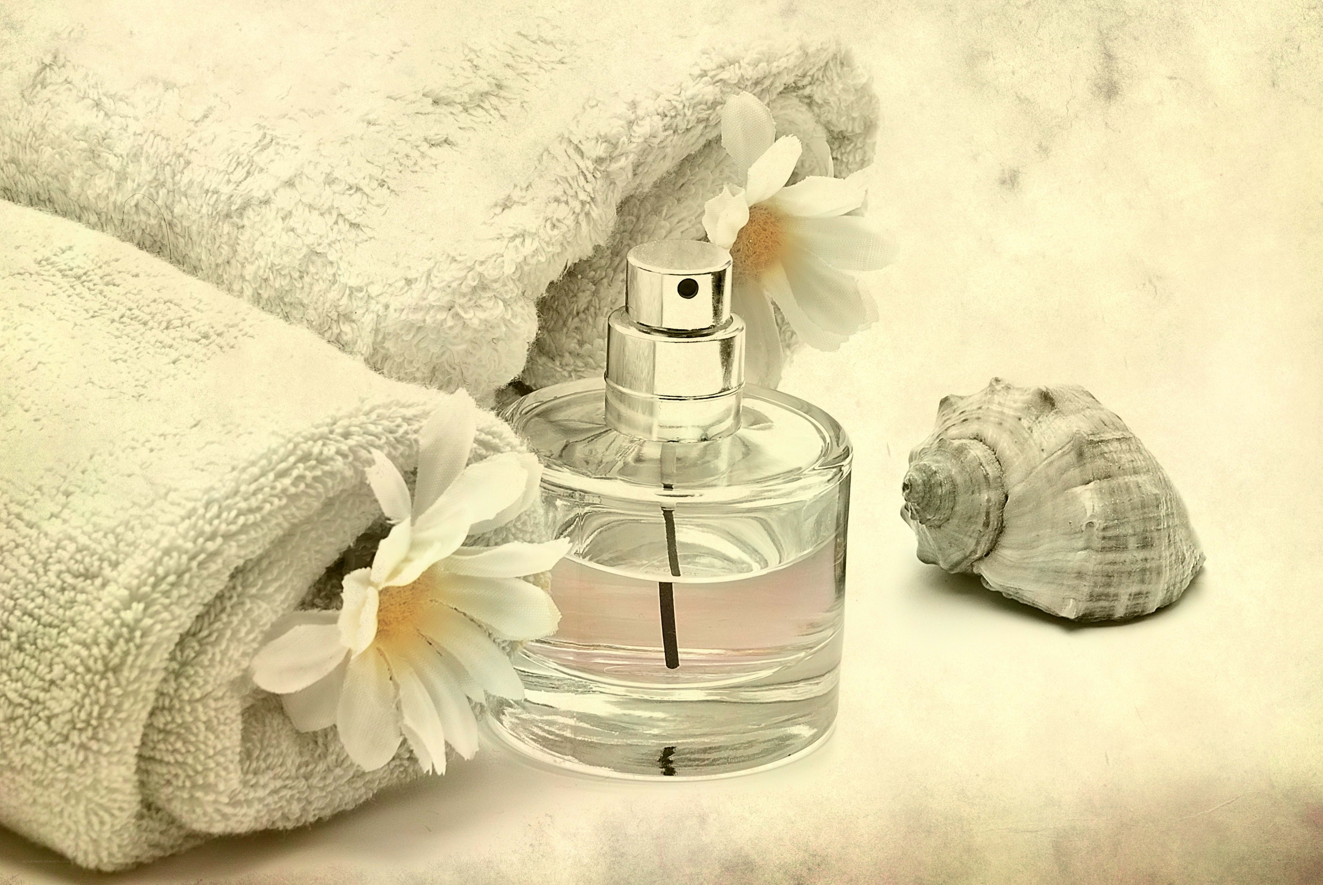 Perfume bottle with towel and seashell