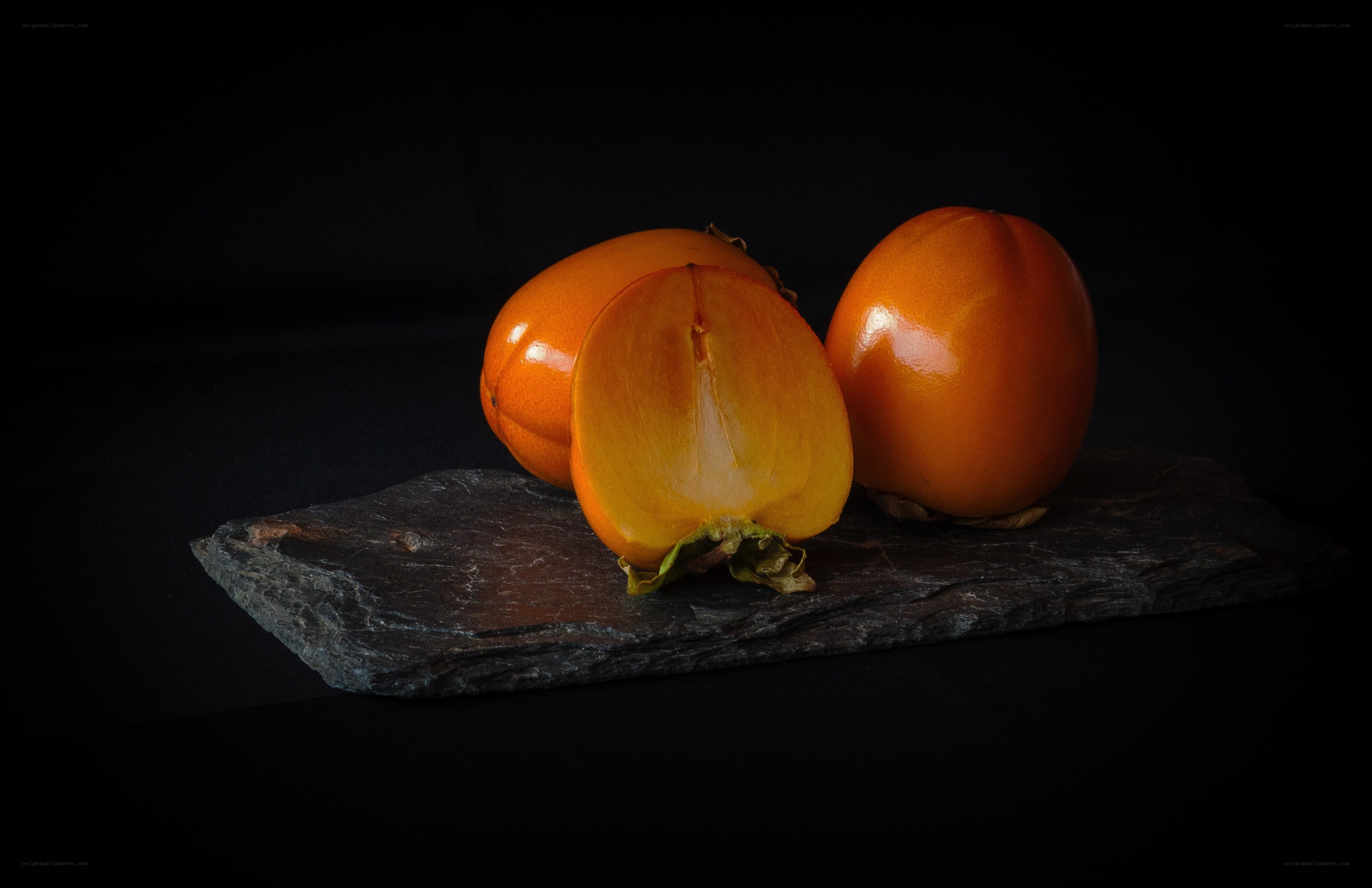 Persimmons on a slate board