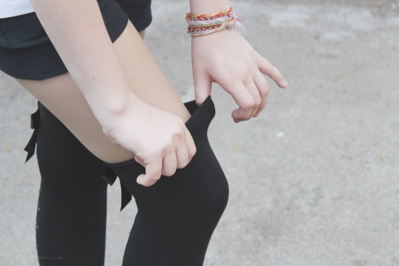 person adjusting black leggings