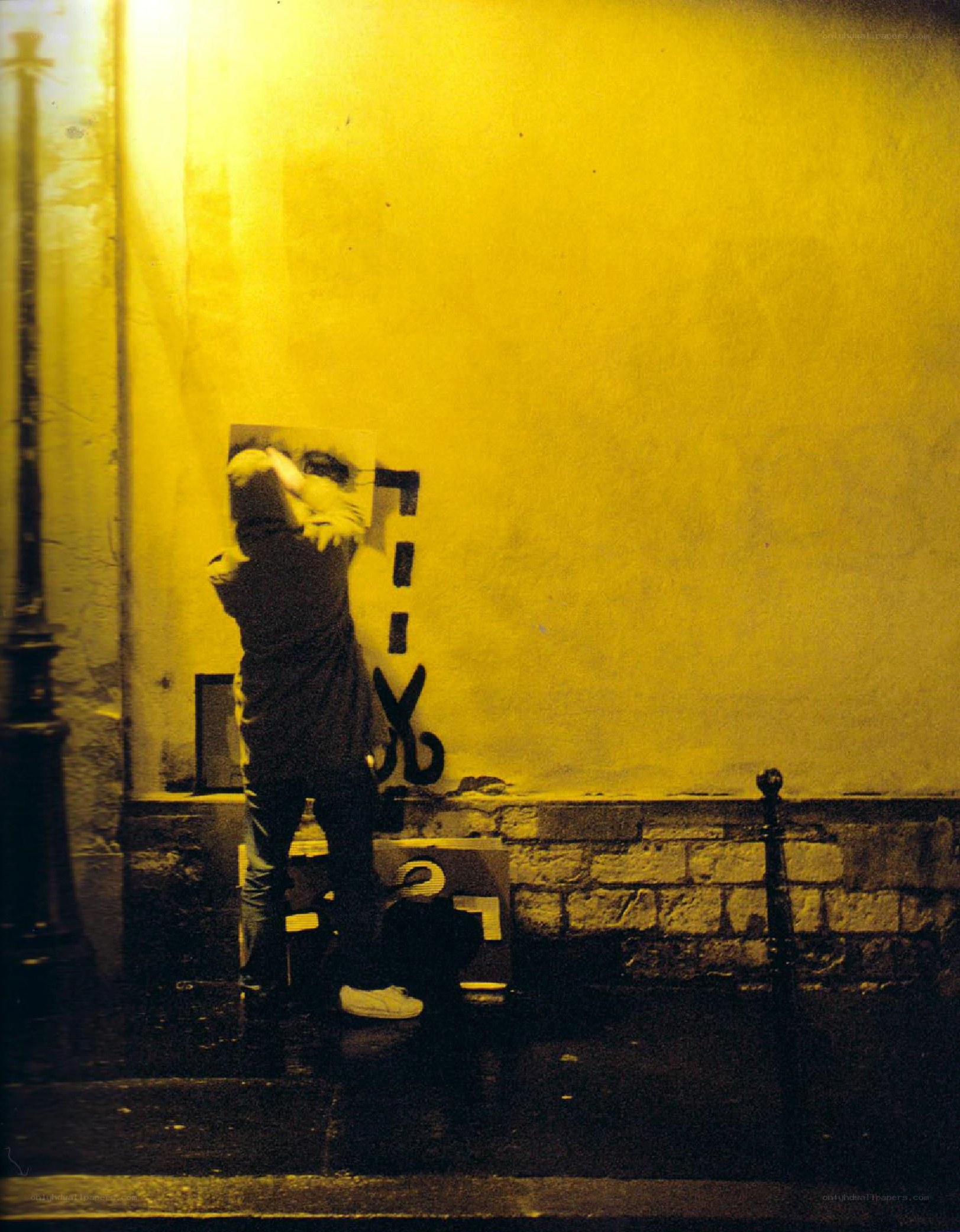 person applying stencil at night