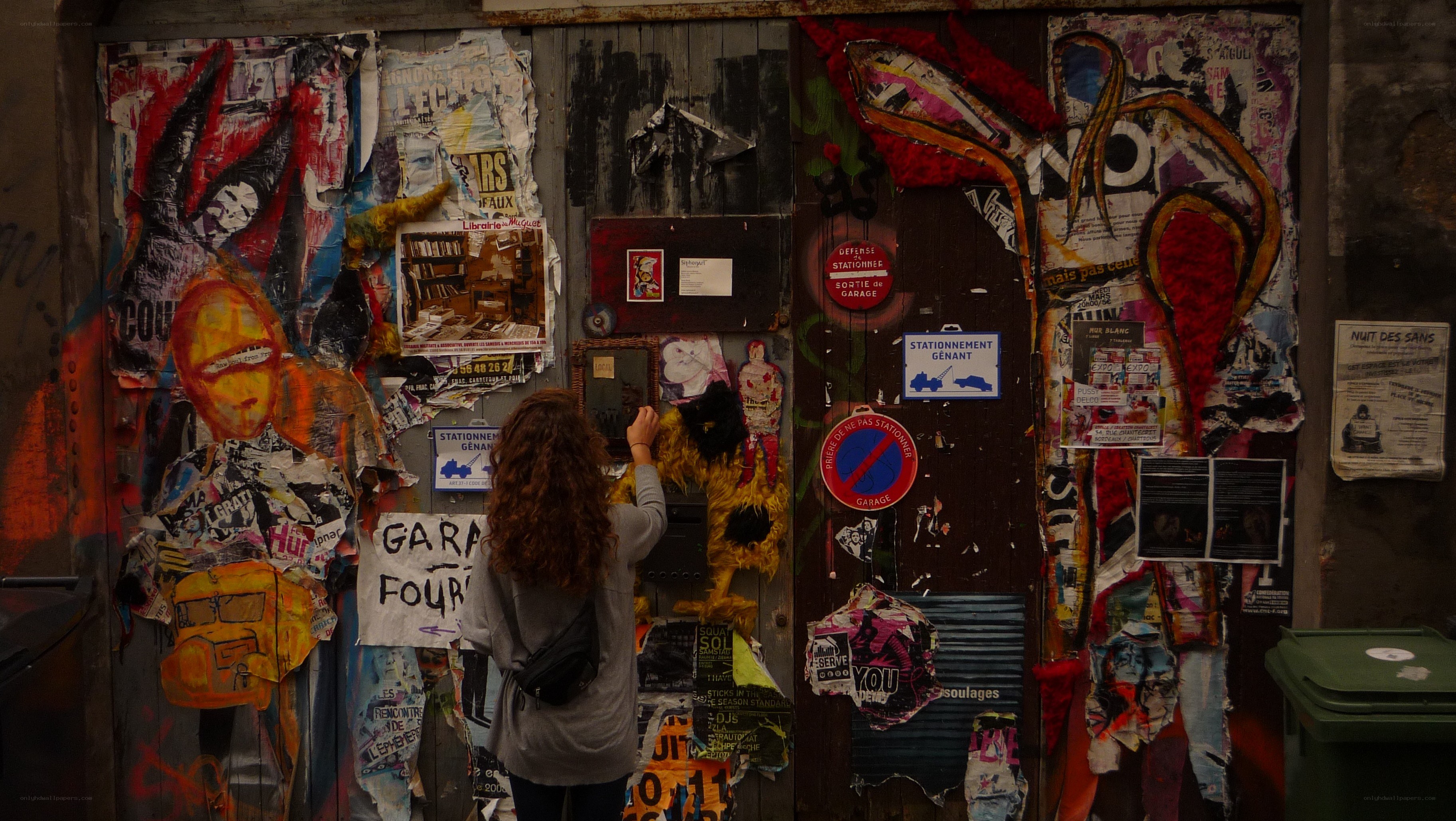 person at a graffiti-covered wall