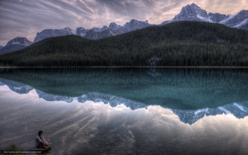 Person at a lake with mountain reflection