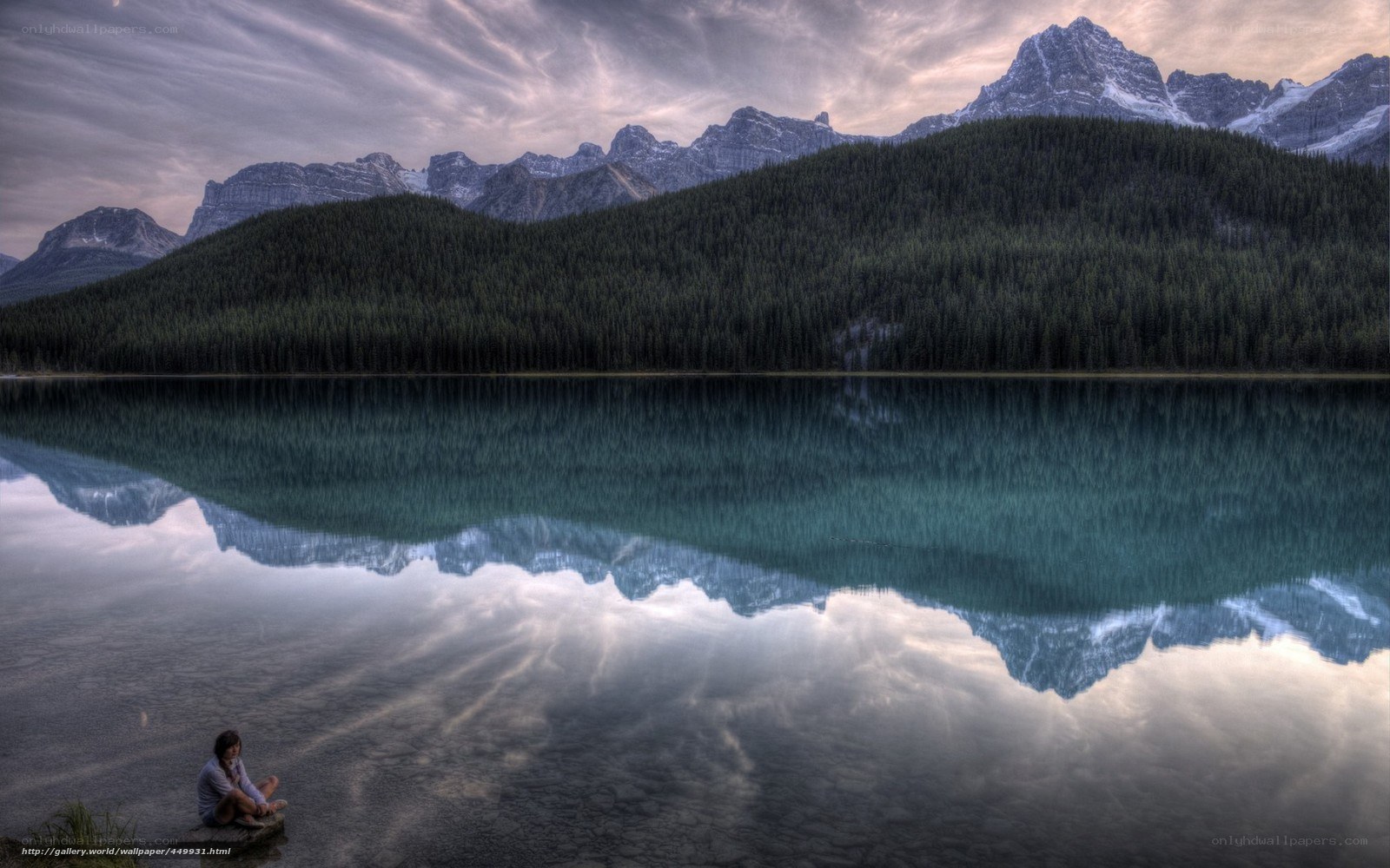 Person at a lake with mountain reflection