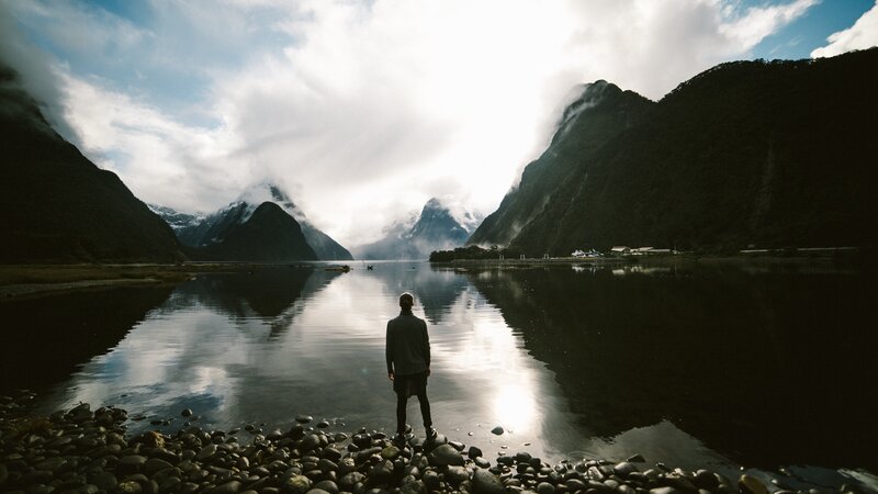 person at a lake with mountains