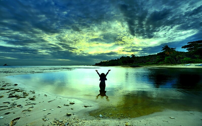 Person at beach with arms raised