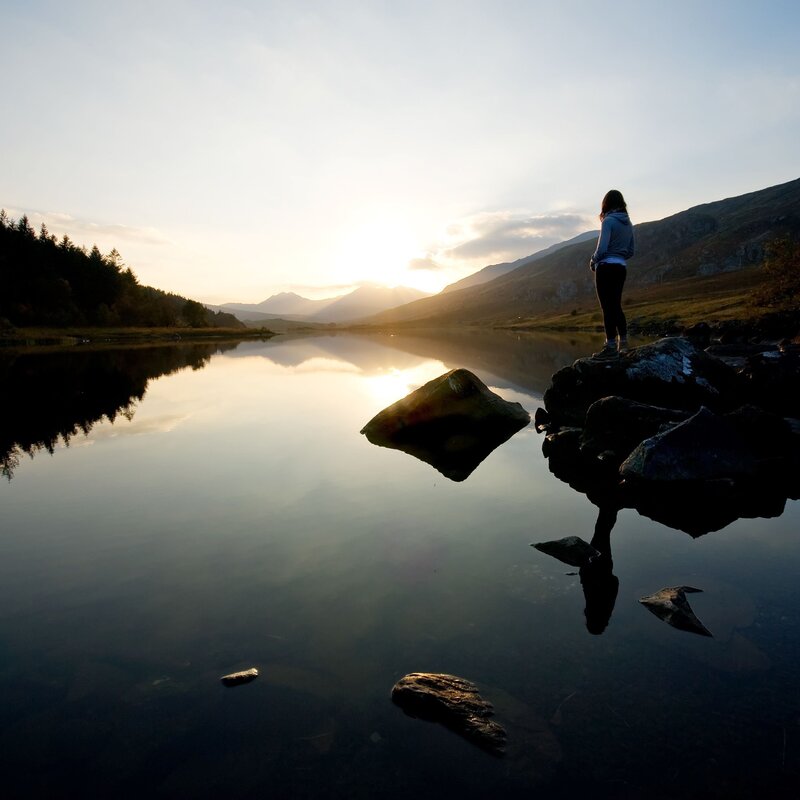 Person at lake during sunset