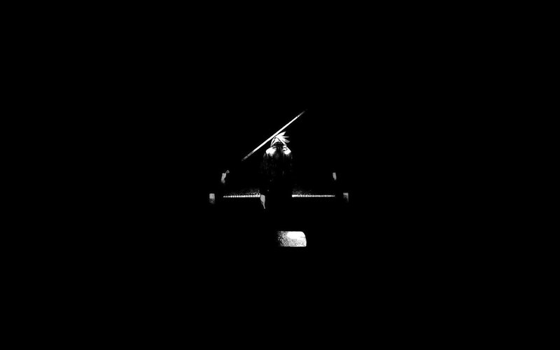 person at piano in darkness