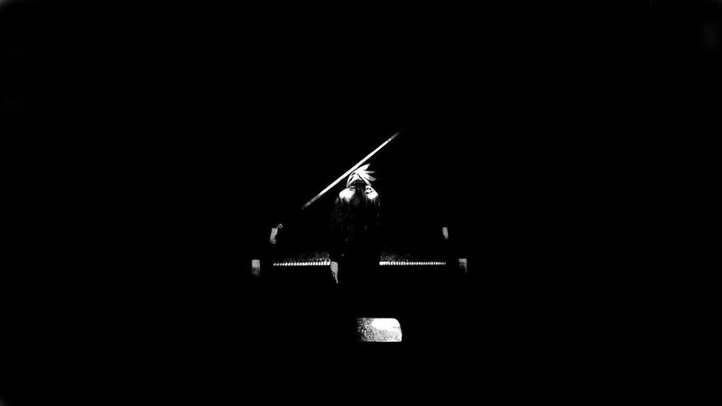 person at piano in darkness