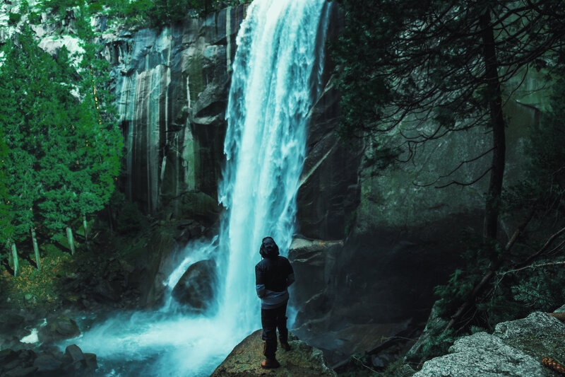 Person at waterfall in forest