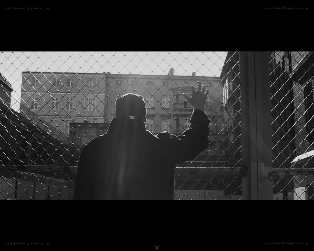 person behind chain-link fence
