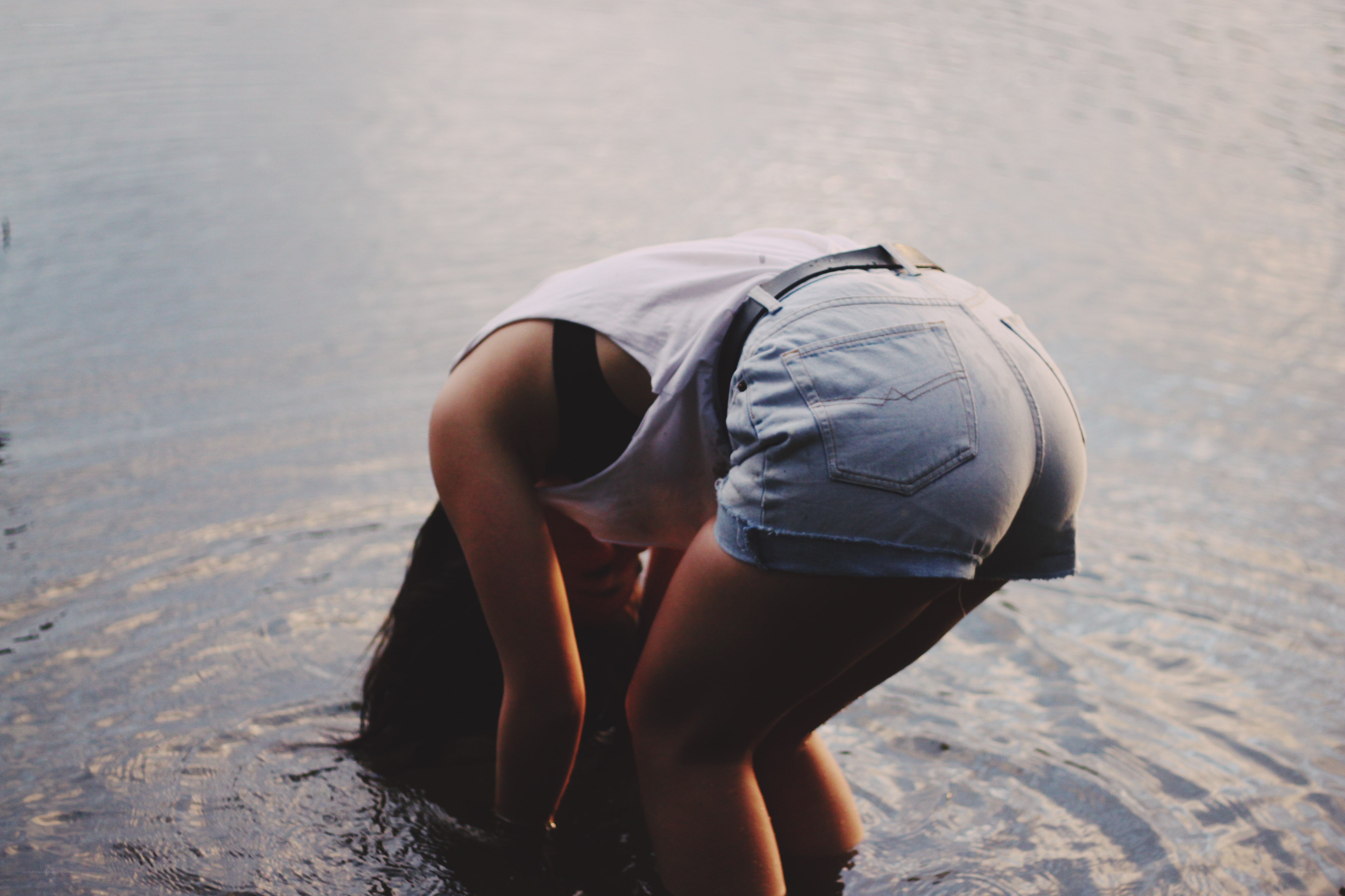 person bending over in water