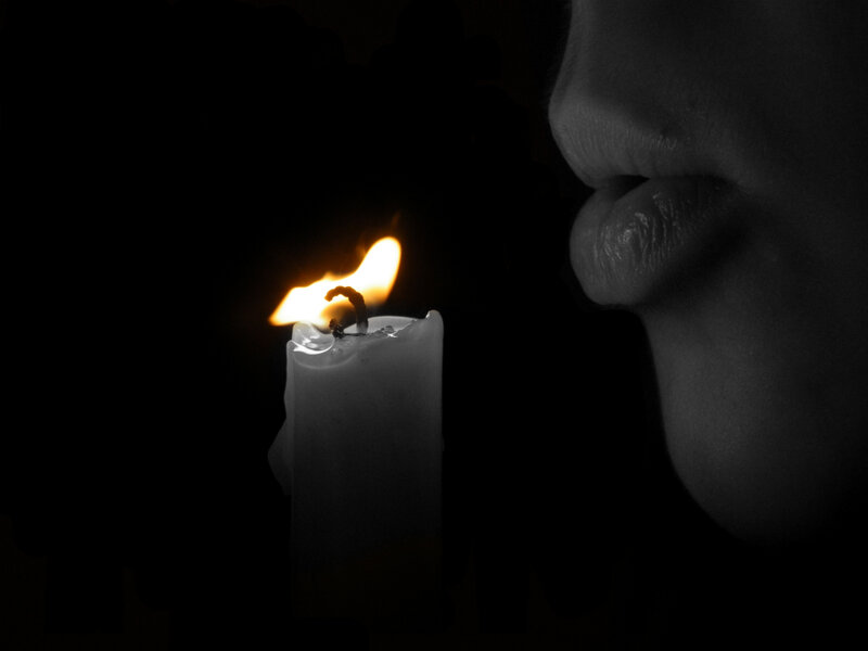 person blowing out a candle