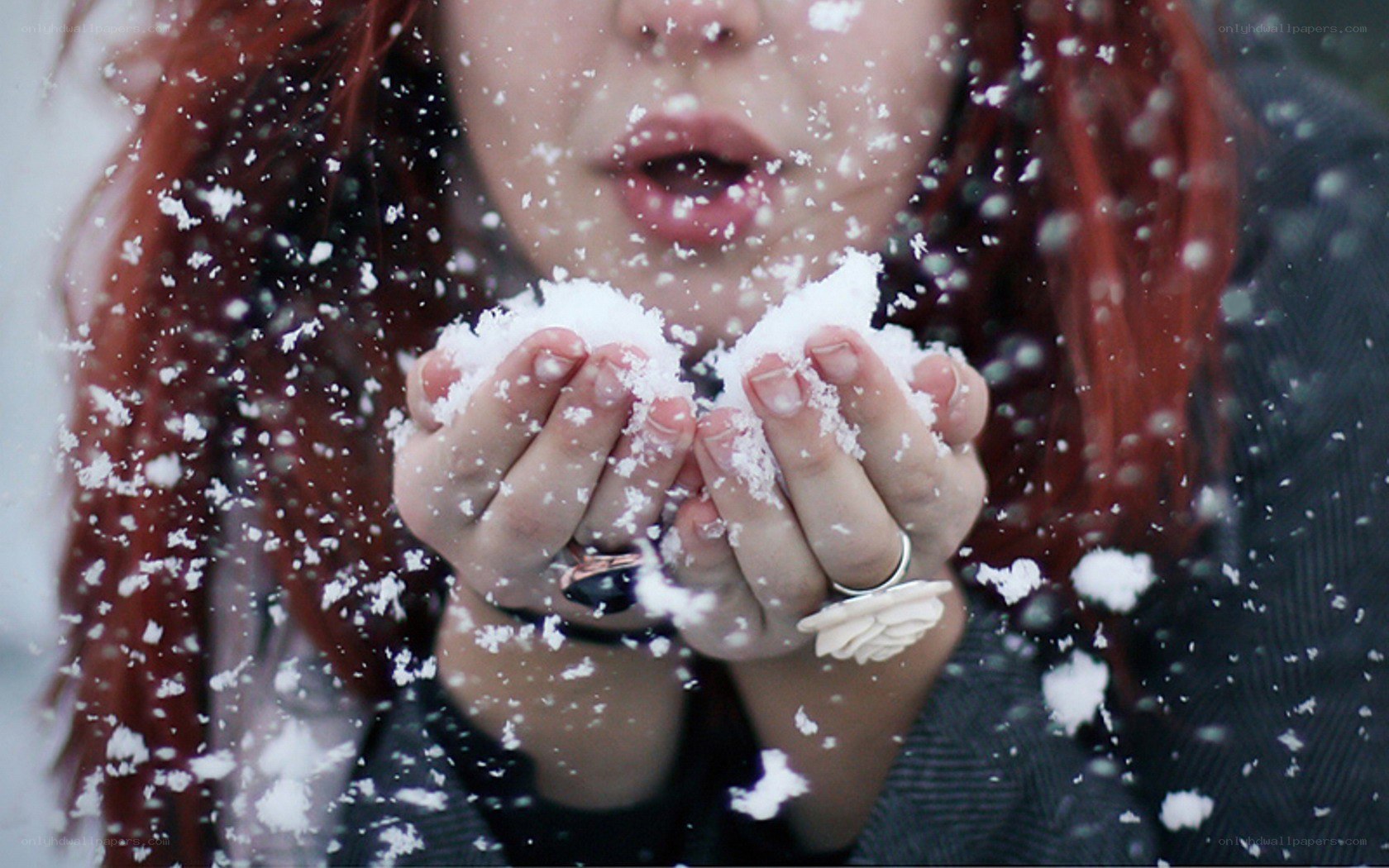 person blowing snow from hands