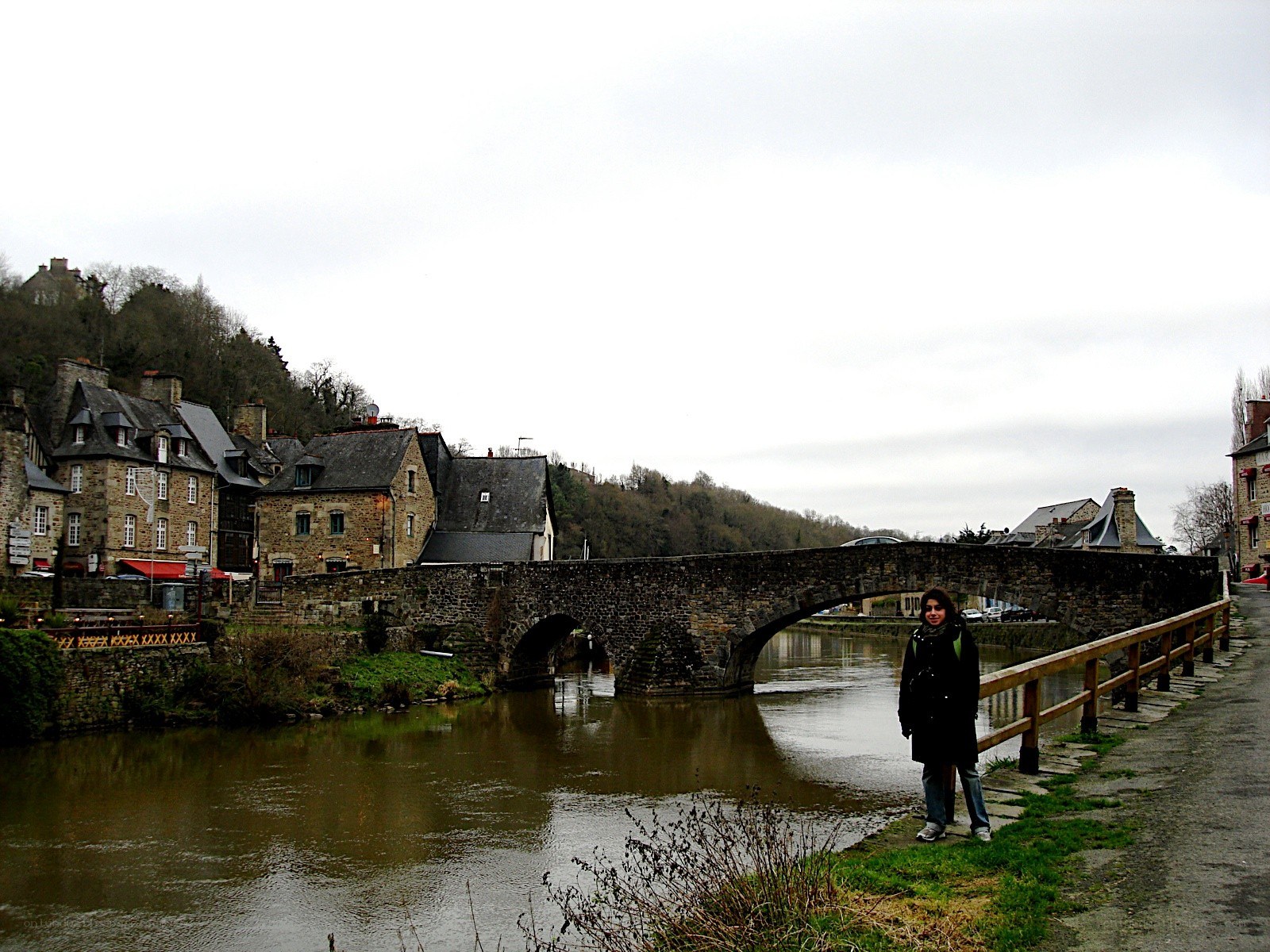 person by stone bridge over river