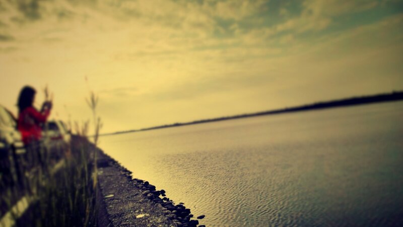 person by the water at dusk