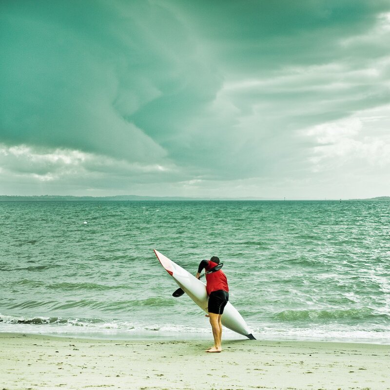 Person carrying kayak on beach