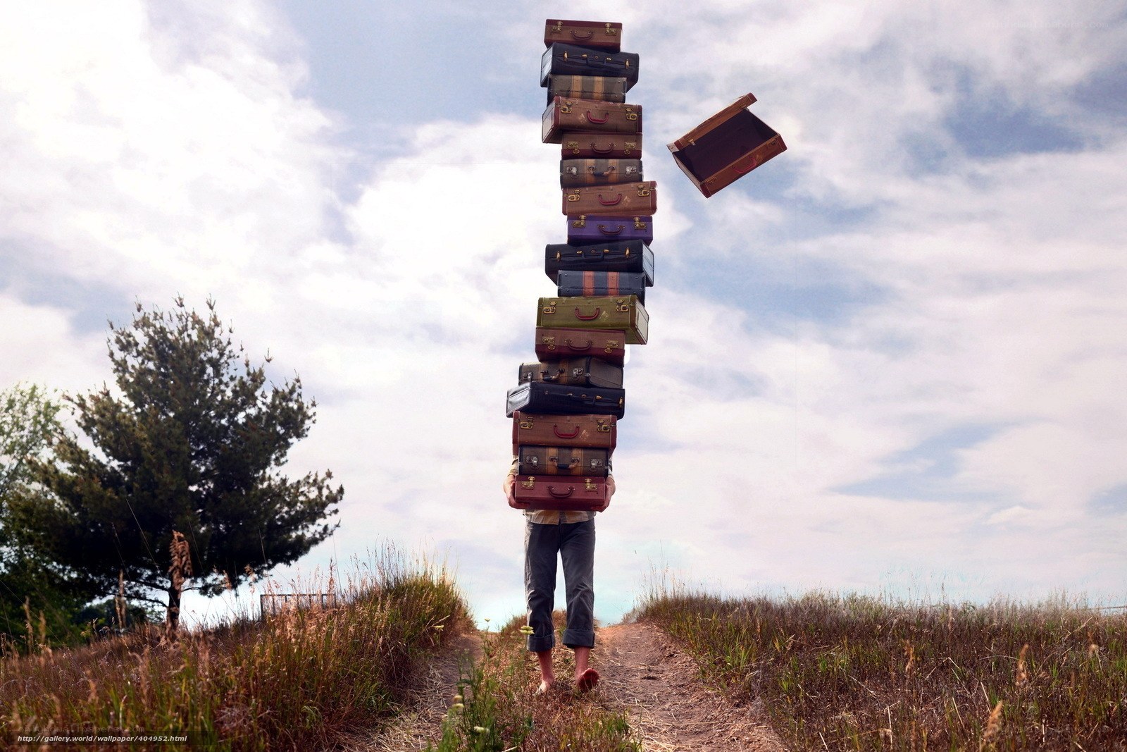 Person carrying tall suitcase stack