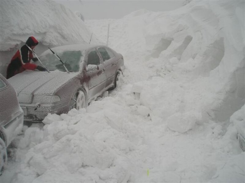 Person clearing snow from car