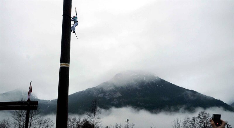 Person climbing a pole with mountains
