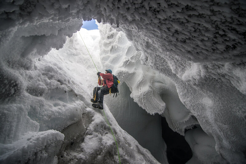 Person Climbing Ice Cave