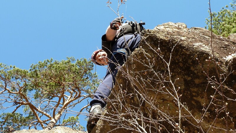Person Climbing Rock — Blue