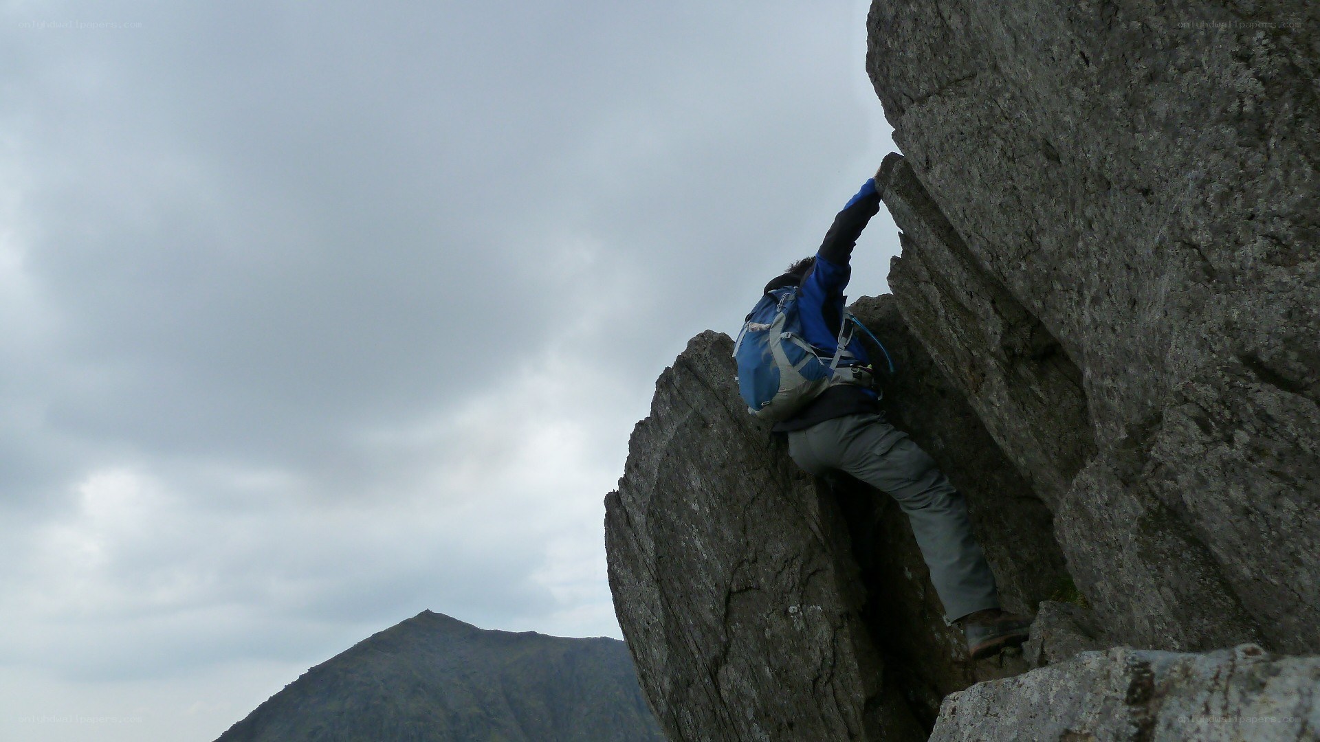 person climbing rocky cliff