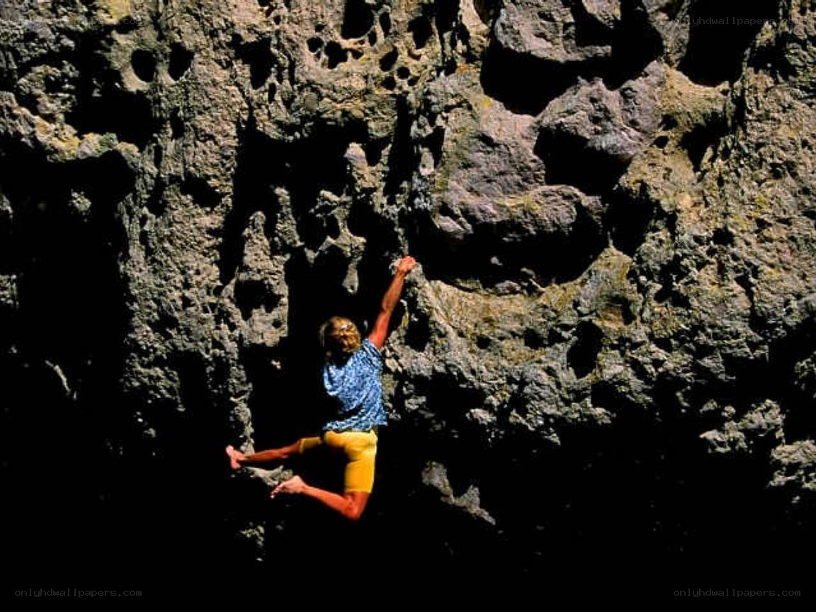 person climbing rocky cliff