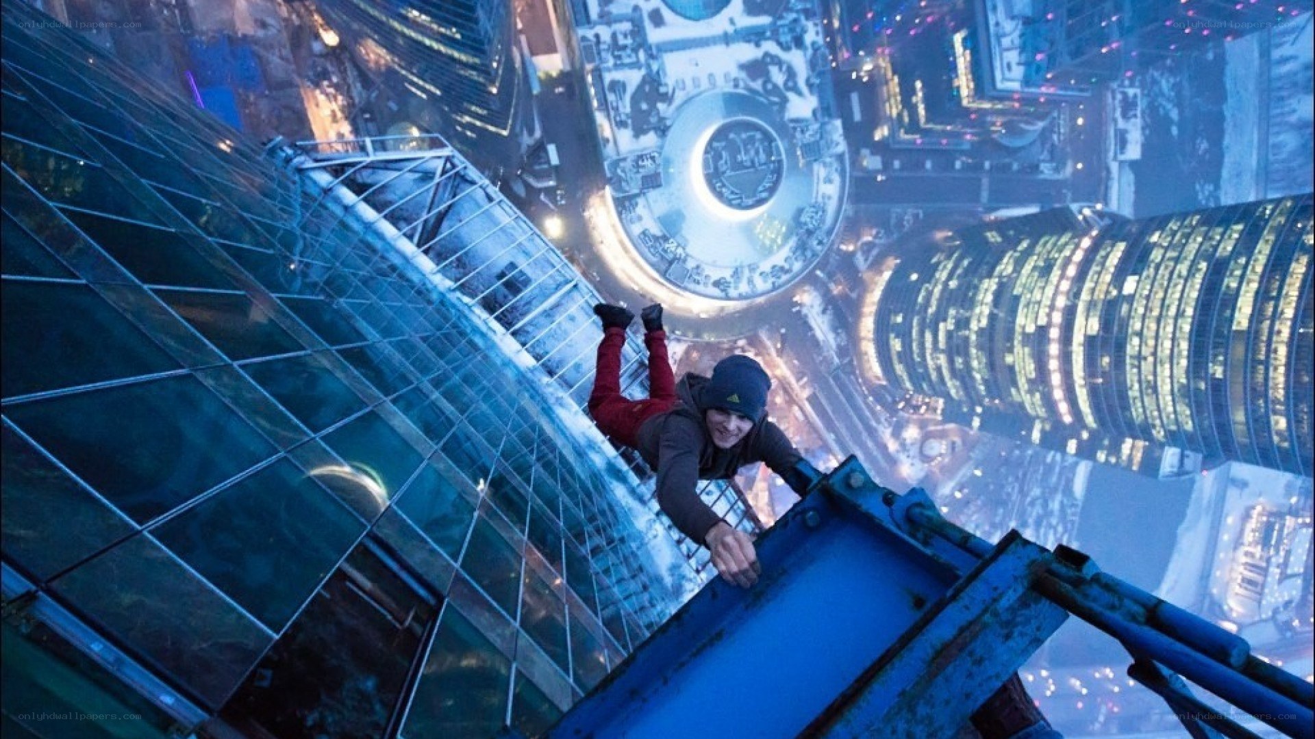 Person climbing skyscraper at night