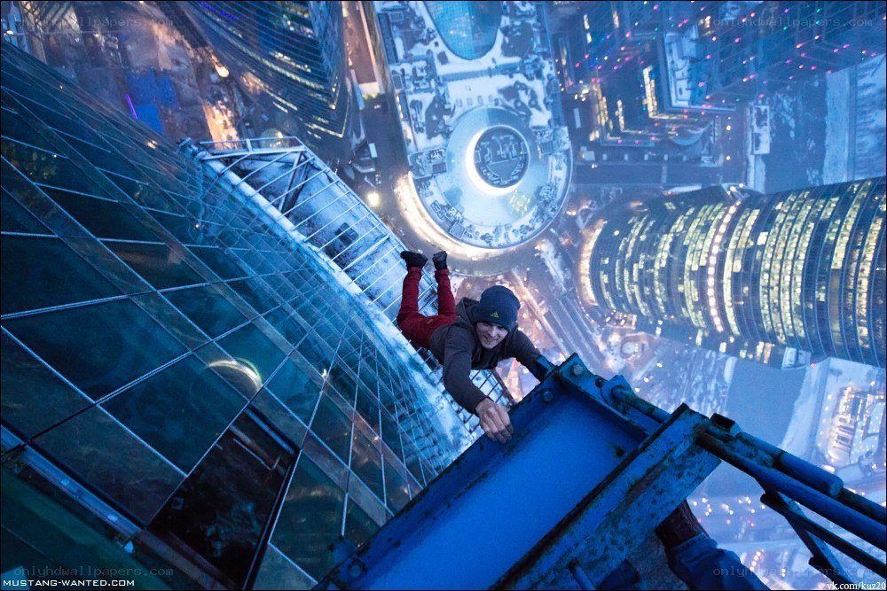 Person climbing skyscraper at night