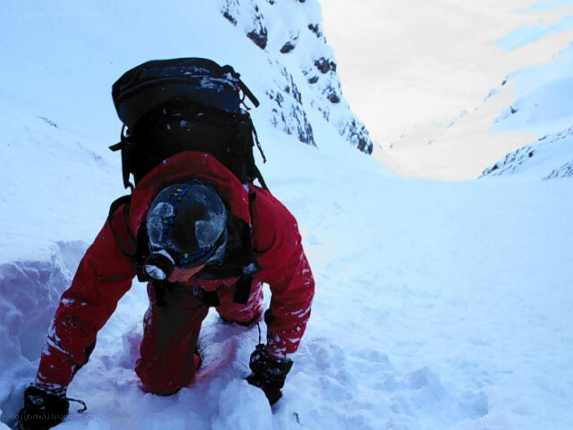 person climbing snowy mountain