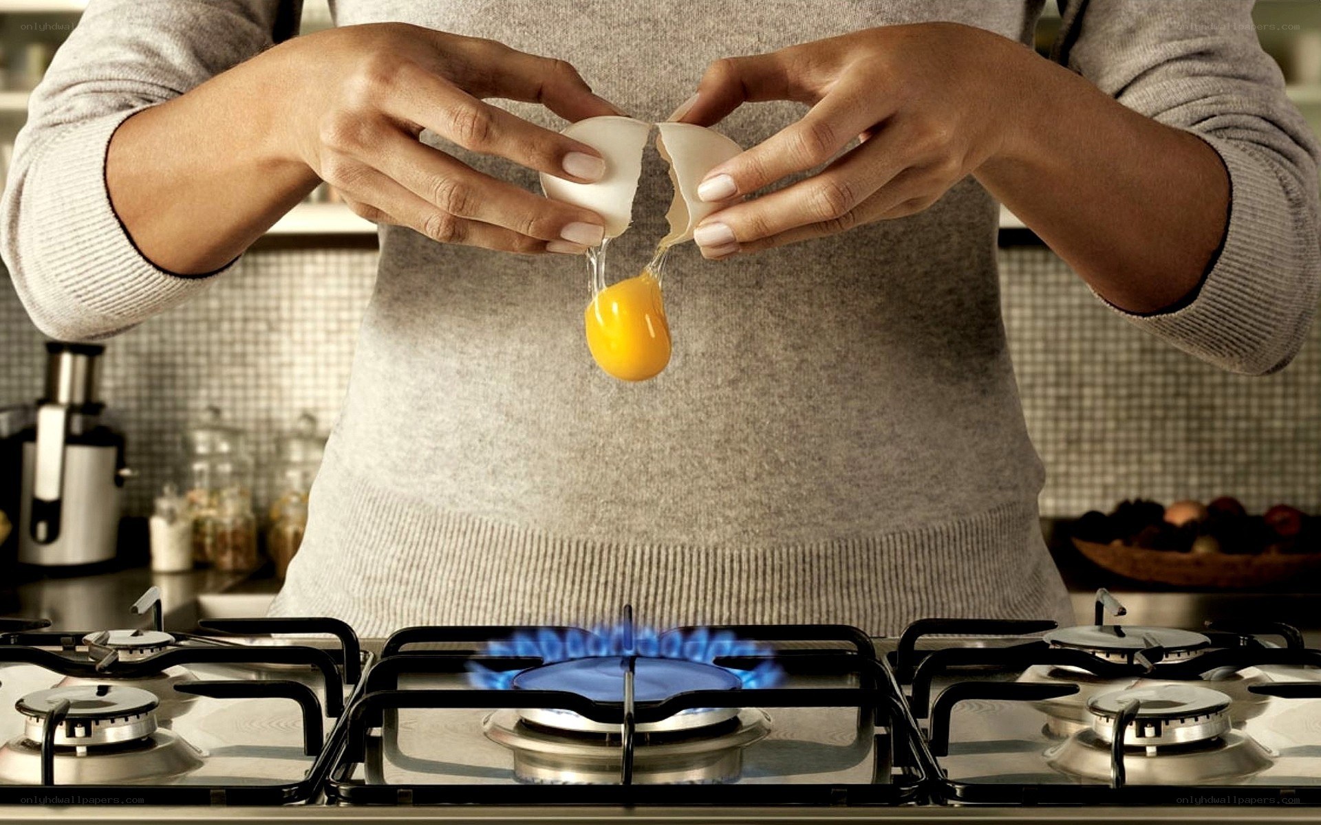 person cracking egg on stove