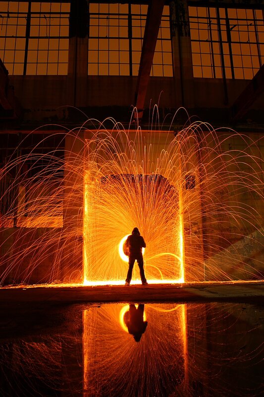 Person creating sparks in industrial space