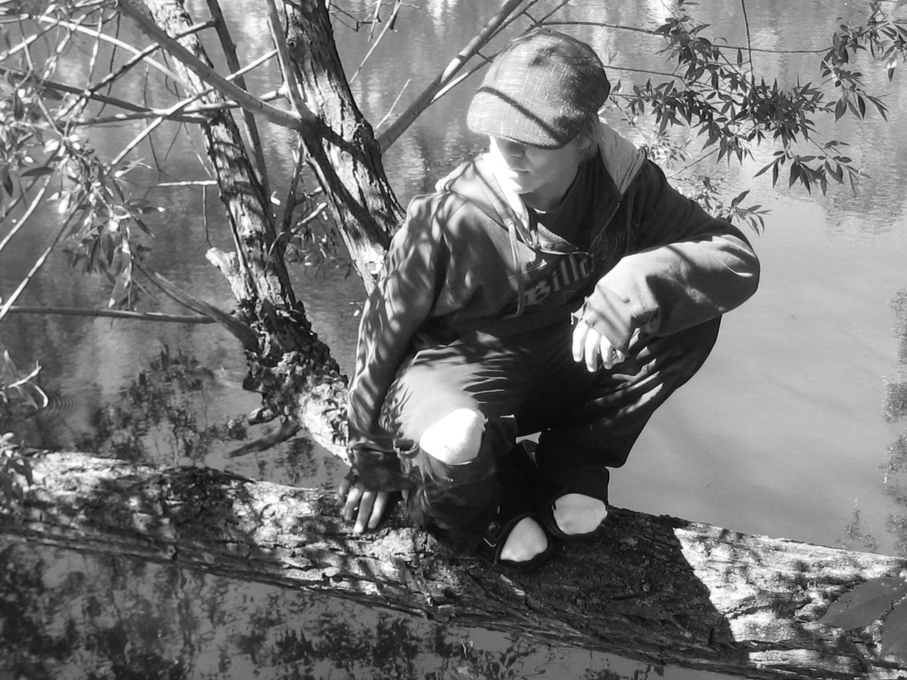 Person crouching on a log