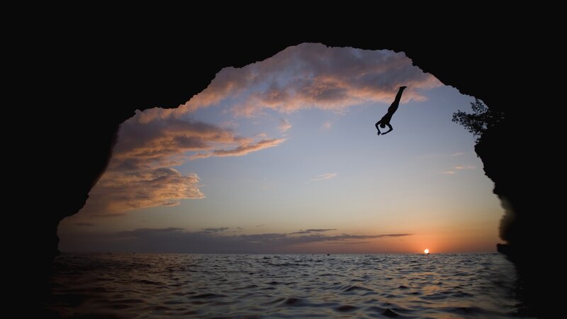 person diving at sunset
