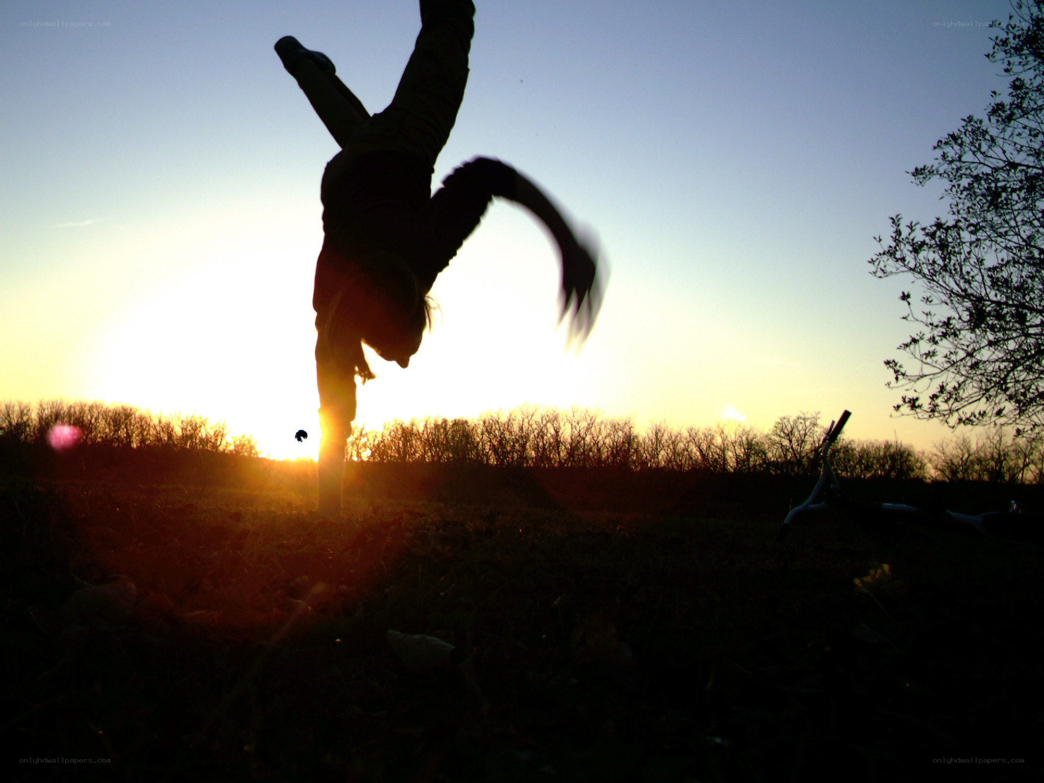 person doing handstand at sunset