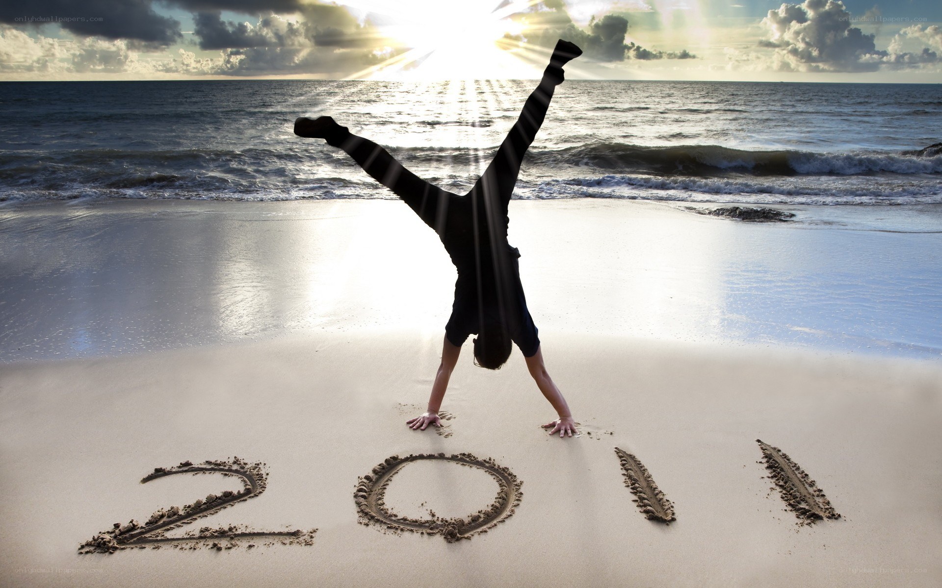 Person doing handstand on beach