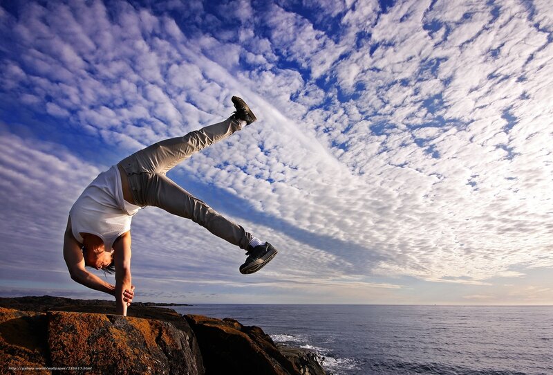 Person doing handstand on cliff