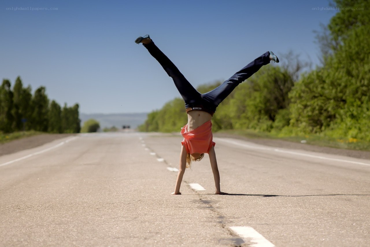 Person doing handstand on road