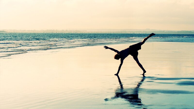 person doing yoga on beach