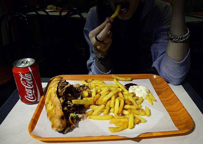 Person eating a sandwich and fries