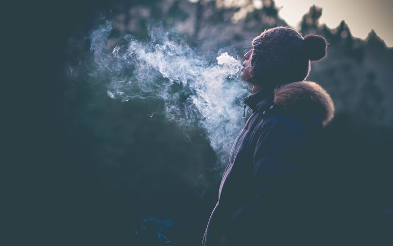 person exhaling vapor outdoors