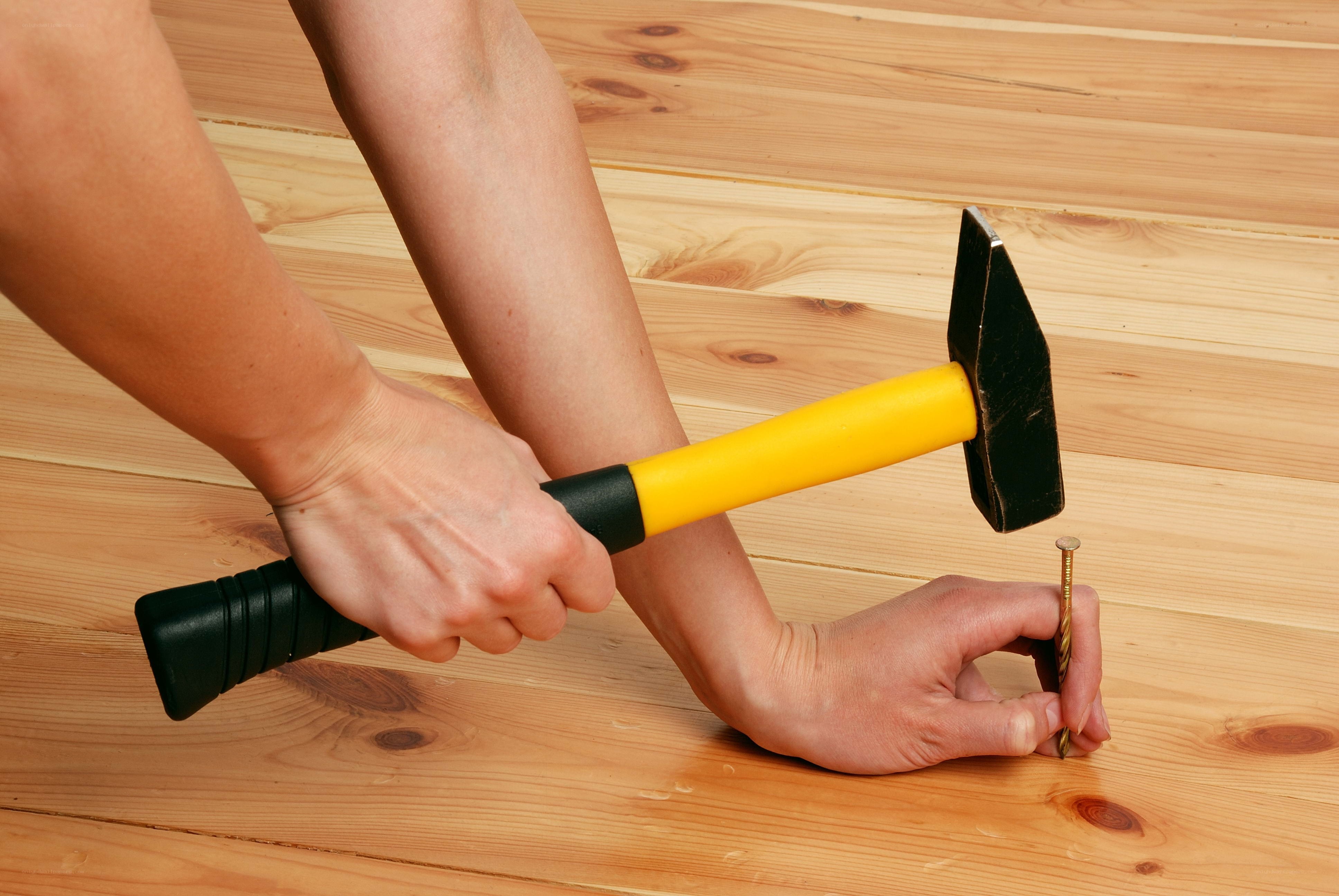 Person hammering nail into wood