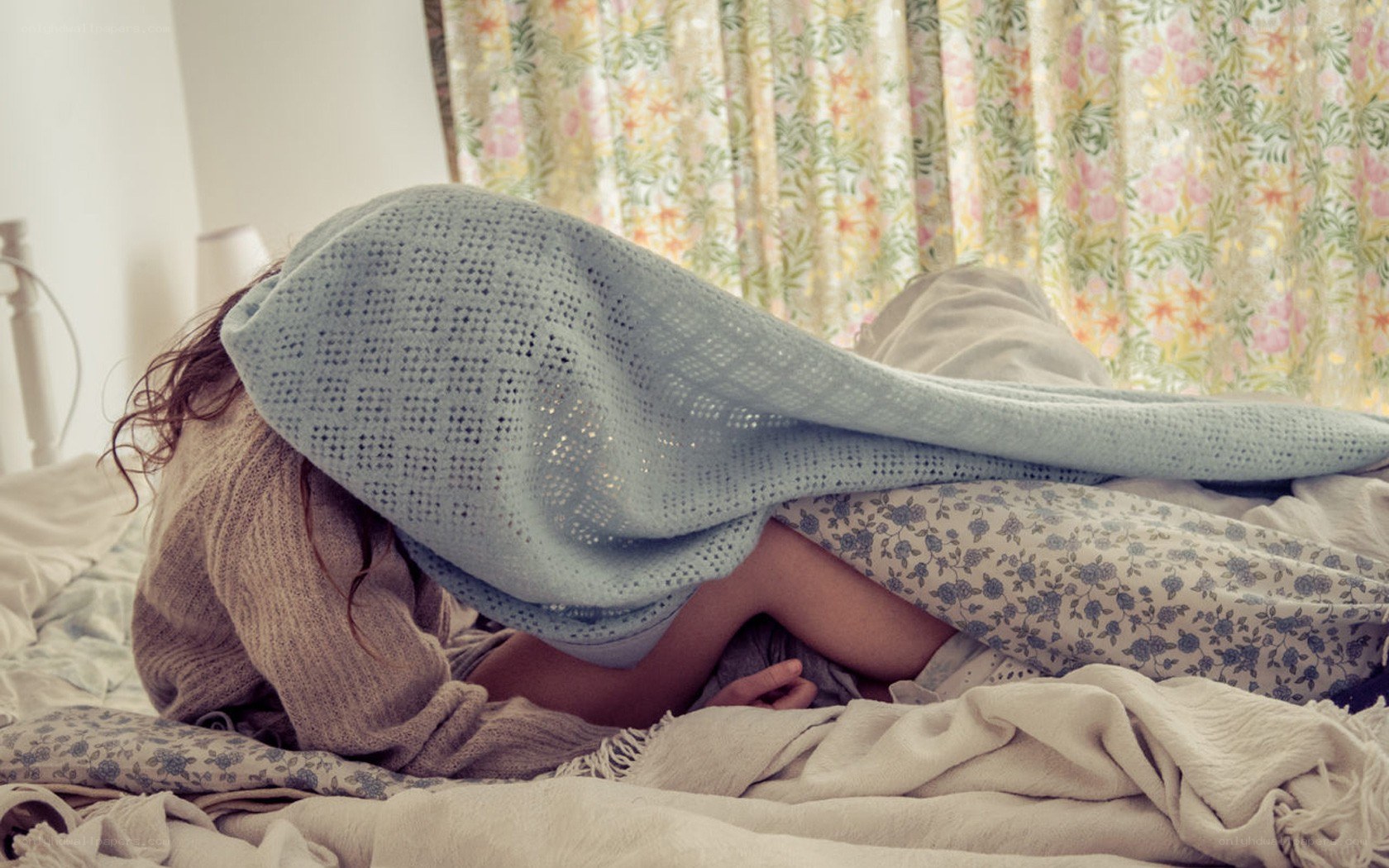 person hiding under blanket