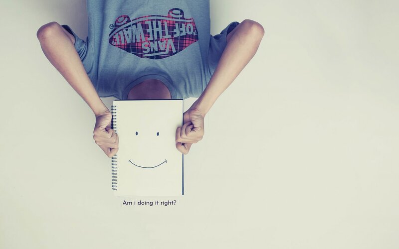 person holding a smiley face notebook